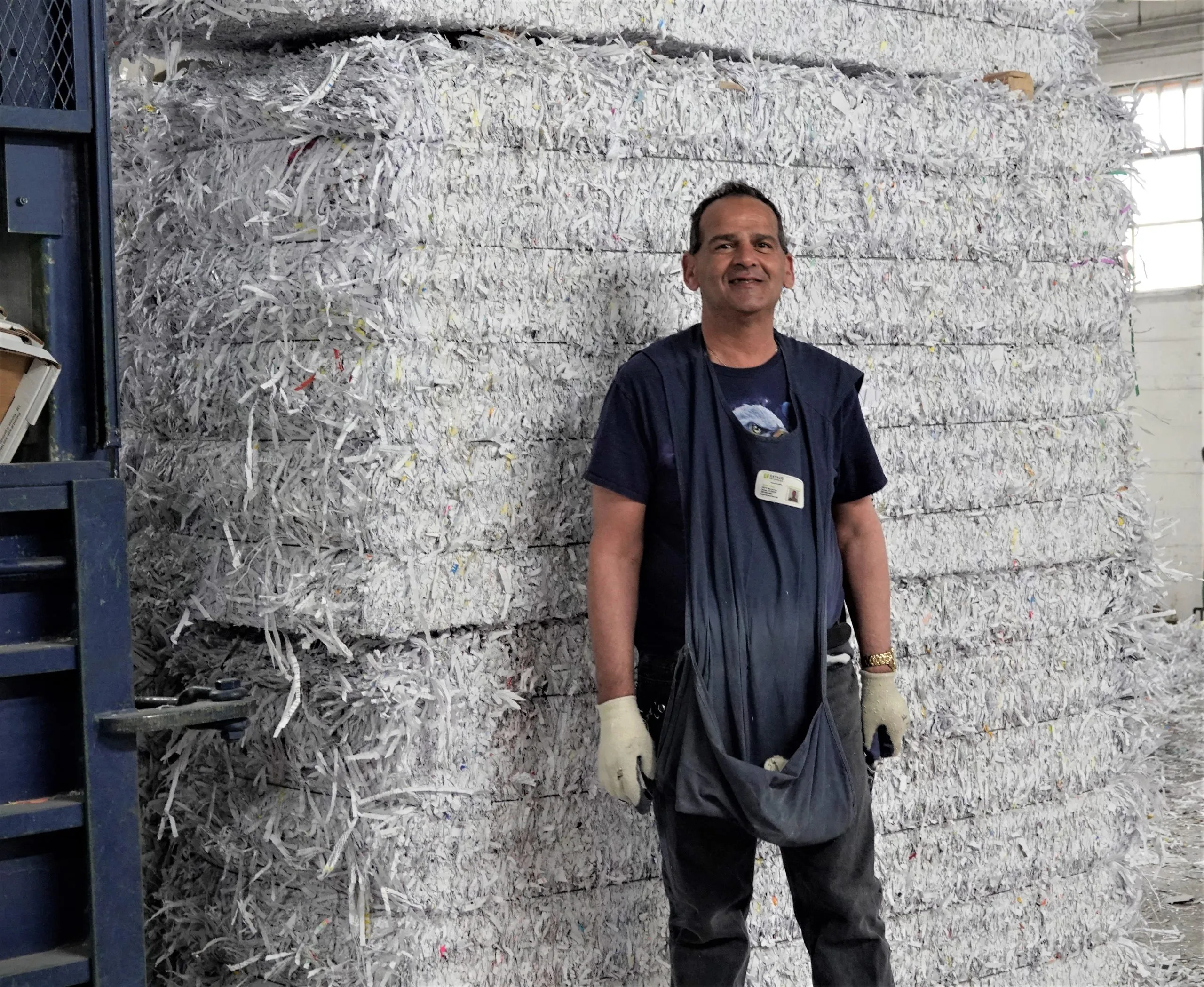 Happy worker in front of shredded documents